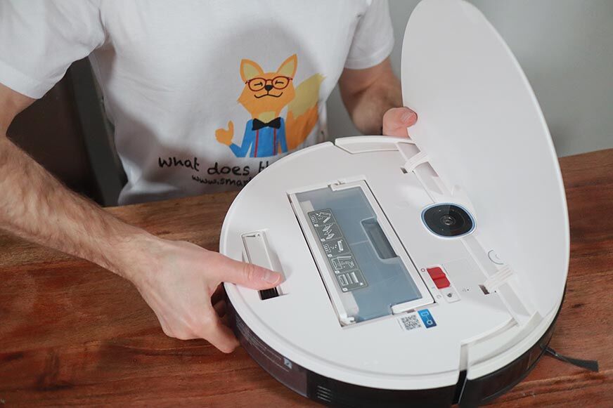 Der Yeedi Vac Max steht mit offener Klappe auf dem Tisch 